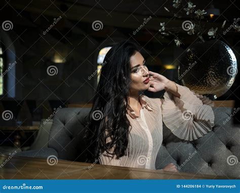 Beautiful Brunette Model Sitting On A Table In A Restaurant And Posing Photo Model On Photo