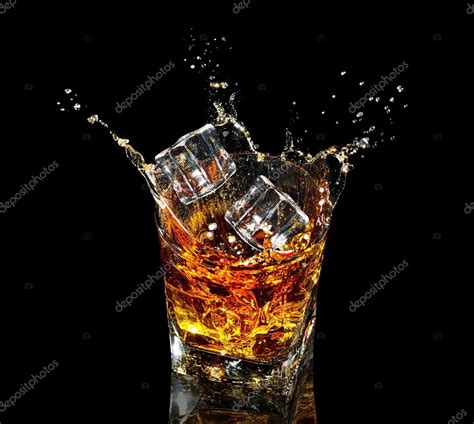 Glass Of Whiskey With Splash On Black Background Stock Photo