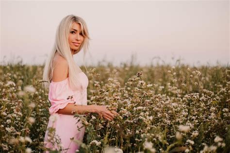 Premium Photo Blonde Woman Posing In The Big Endless Field Of Daisies In Summer Evening