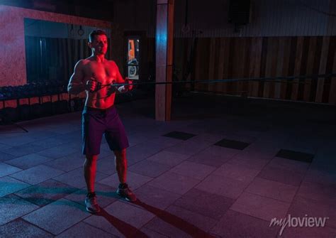 Muscular Powerful Man With Naked Torso Trains With Expander Fitness Posters For The Wall