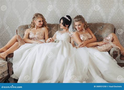 A Brunette Bride In A White Elegant Dress And Crown And Her Blonde