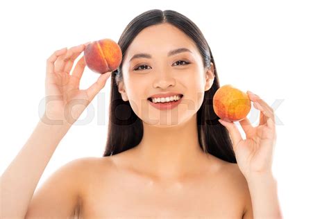 Naked Asian Woman Holding Ripe Peaches While Looking At Camera Isolated On White Stock Image