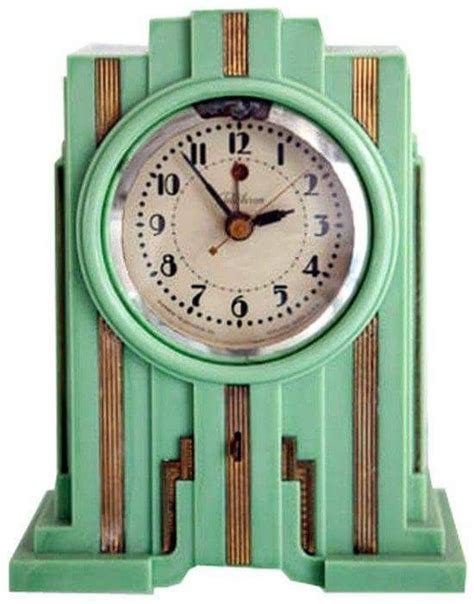 A Green Clock With Gold Trim Around The Face