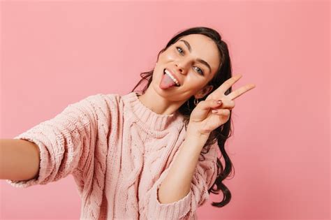 Free Photo Naughty Brunette Shows Peace Sign On Pink Background Girl In Excellent Mood Shows