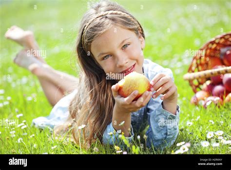 Child Eating Apple In A Field Stock Photo Alamy