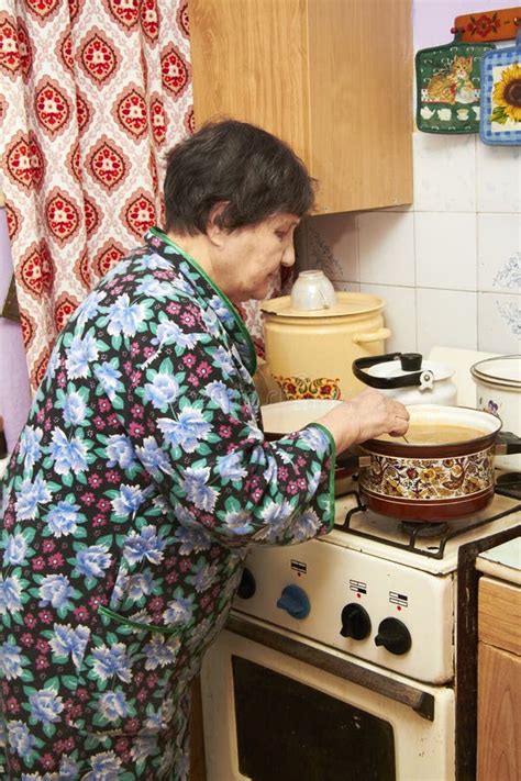 Elderly Woman Cooking Soup On The Stove Stock Photo Image Of Robe