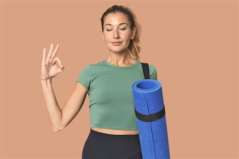 Premium Photo Blonde Athlete With Yoga Mat In Studio