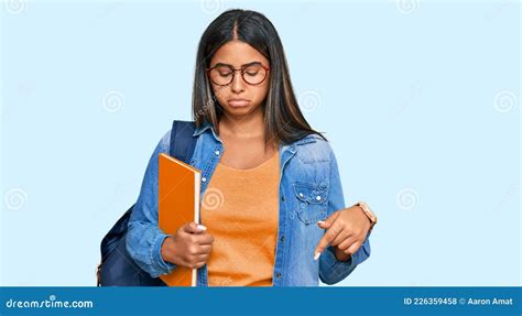 Una Joven Latina Con Una Mochila Estudiantil Y Sosteniendo Libros Apuntando Hacia Abajo Con Un