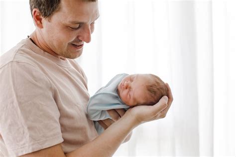 Padre Sosteniendo A Su Hija Recién Nacida Foto Premium