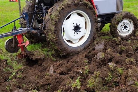 Um trator um arado ara um campo agrícola na primavera para o