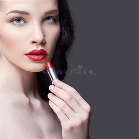 Η νέα γυναίκα Brunette χρωματίζει το χειλικό φωτεινό κόκκινο κραγιόν της Φωτεινό βράδυ Makeup