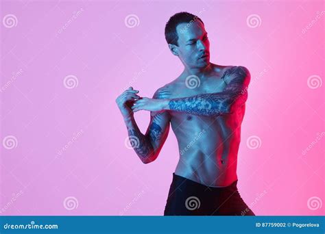 Muscular Sport Man Naked Torso Making Arm Stretch On A Color Background Studio Fashion Portrait