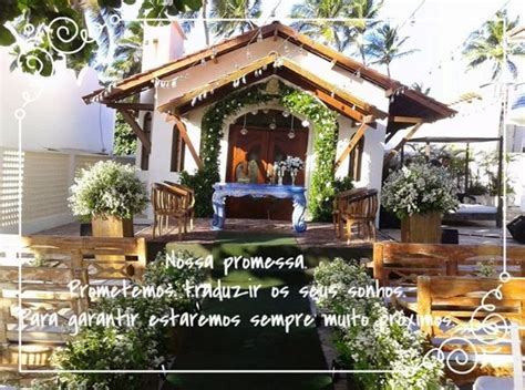 A Gazebo With Flowers And Greenery Around It