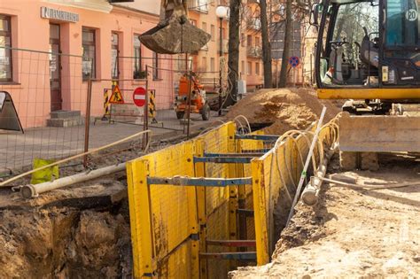 Excavator Filling Deep Excavation Supported By Trench Box With Pipe