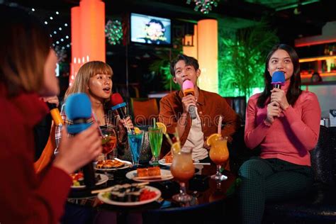 Singing Songs At Karaoke Club Group Of Friends Having Fun Stock Image