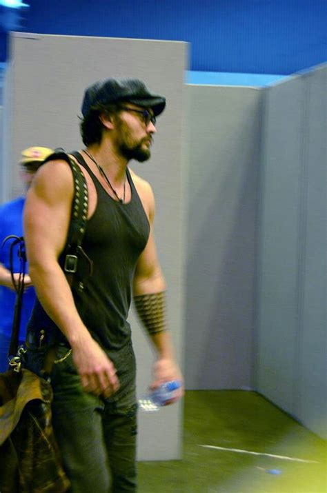 A Man With Tattoos On His Arm Holding A Frisbee While Standing Next To