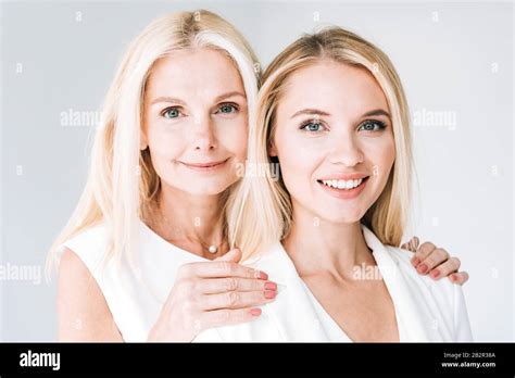 Blonde Smiling Mature Mother And Adult Daughter Isolated On Grey Stock Photo Alamy