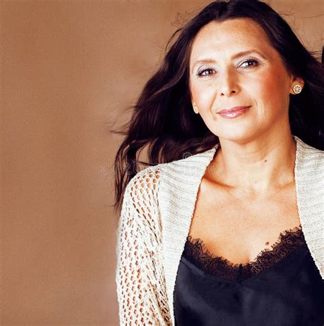 H Bsche Brunette Berzeugte Reife Frauenaufstellung Nett Auf Warmem Hintergrund Lebensstilleute