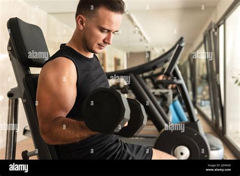 Athletic Man Working Out With A Dumbbells During His Workout In The Gym