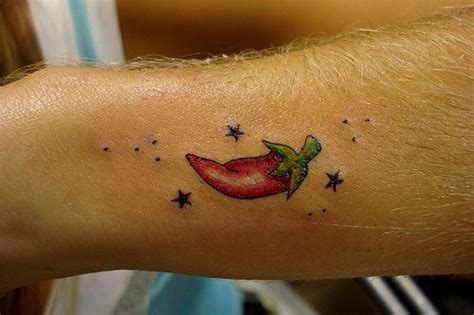 A Person With A Tattoo On Their Arm That Has A Red Pepper And Stars