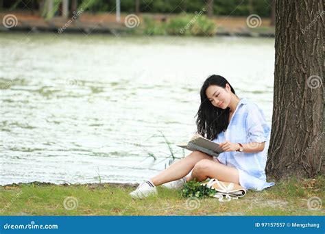Fille Chinoise Lisant Un Livre Sous L Arbre La Belle Jeune Femme Blonde Avec Le Livre S Asseyent