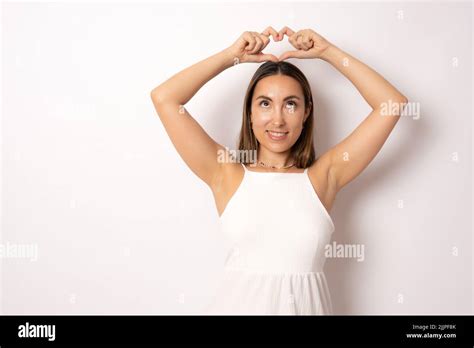 Portrait Of Lovely Charming Brunette Girl Making Love Symbol Heart Figure With Fingers Over Head