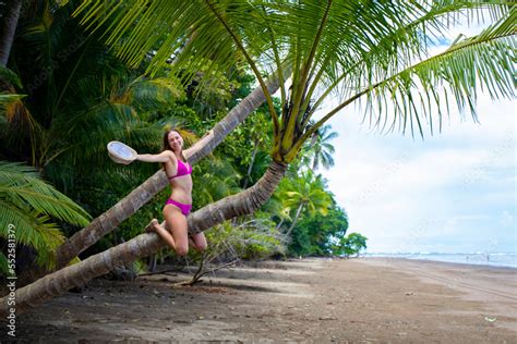 A Beautiful Girl In Bikini Sits On A Palm Tree On A Tropical Paradise Beach In Costa Rica Beach