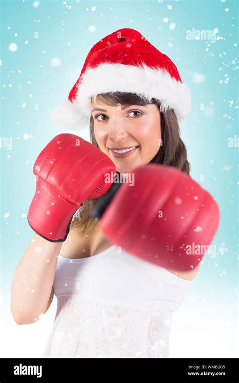 Festive Brunette Punching With Boxing Gloves Against Blue Vignette