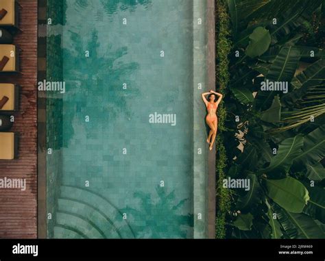 Vue aérienne de la jeune femme au bord de la piscine Femme en bikini se relaxant au bord de la