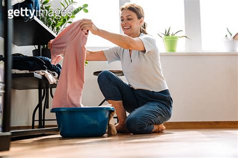Ginger mature woman smiling while doing housework 이미지 1400823986 게티이미지뱅크