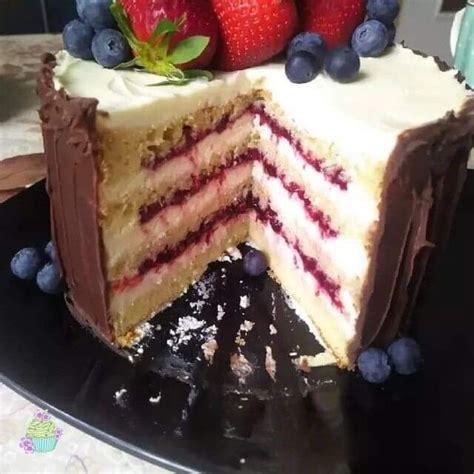 A Cake With Chocolate Frosting And Strawberries On Top Is Cut In Half