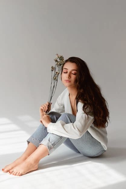 Encantadora Chica Modelo Con Maquillaje Nude Con Jeans Y Blusa Desabrochada Posando Con Una