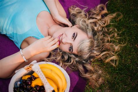 Belle Fille Sur Un Pique nique Dans Le Parc Mange Une Pêche Blonde Allongée Sur Un Couvre lit
