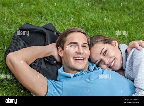 Portrait Of Young Couple Lying On Grass Stock Photo Alamy