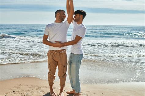 Joven Pareja Gay Sonriendo Feliz Bailando En La Playa Foto De Archivo Imagen De Gente Costa