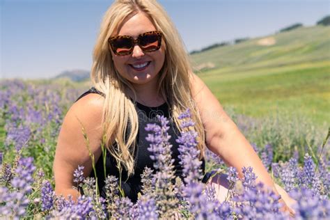 Jolie Femme Blonde Assise Dans Un Champ De Fleurs Sauvages Lupines Posant Avec Des Lunettes De