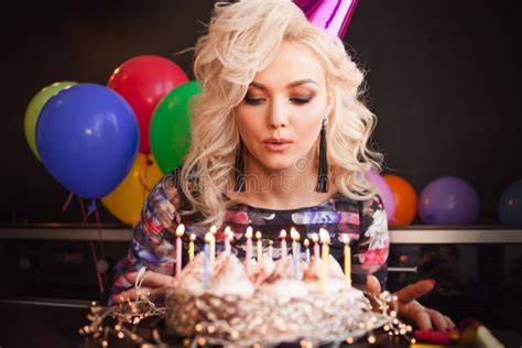 Birthday A Young Woman Blows Out The Candles On Her Birthday Cake