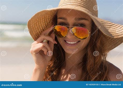 Femme Caucasienne De Jeune Bikini Avec Le Chapeau Regardant Au Dessus Des Lunettes De Soleil
