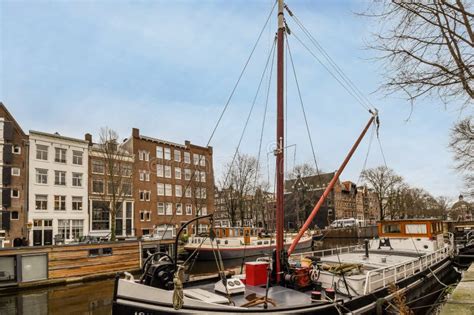 A Boat Is Docked In A Canal With Buildings Editorial Photography