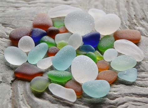 Several Different Colored Sea Glass Pieces On A Rock