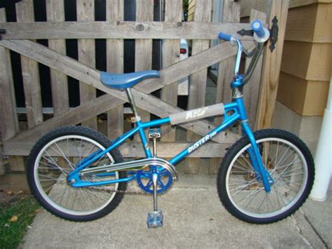 Blue Bmx Bike Parked In Front Of A Wooden Fence