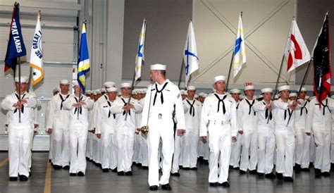 a group of men in white uniforms standing next to each other with flags behind them