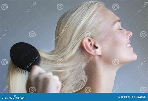 Beautiful Blonde Woman Brushing Hair In A Salon Beauty Hair Model