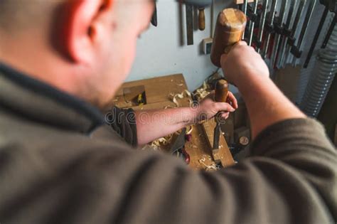 Master Carpenter Working On Wood In His Workshop Surrounded By Tools