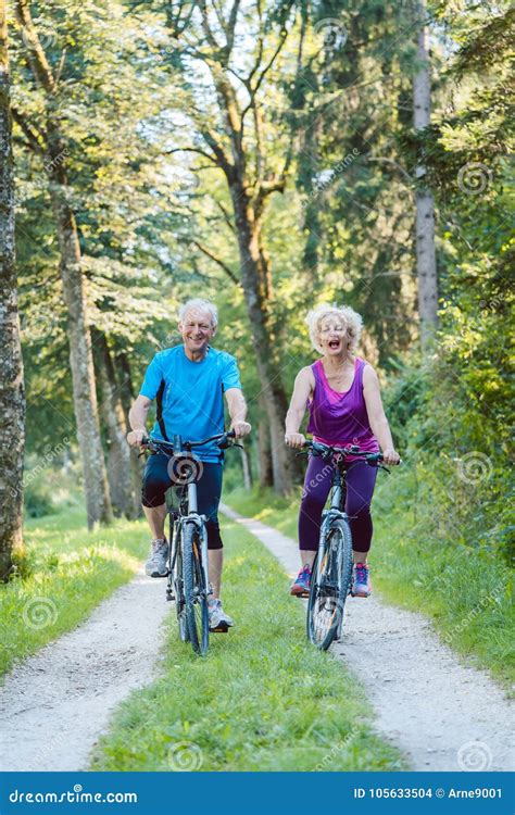 Den Lyckliga Och Aktiva Höga Parridningen Cyklar Utomhus I Pet