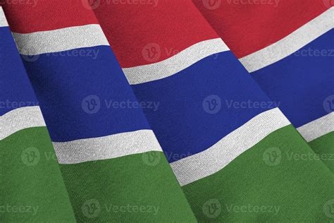 Gambia flag with big folds waving close up under the studio light