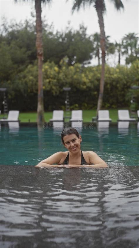 A Beautiful Brunette Woman Relaxes In An Outdoor Bali Resort Pool Embodying Leisure And