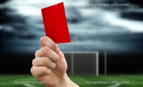 Hand Holding Up Red Card Against Football Pitch Under Stormy Skyのイラスト素材