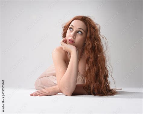 Full Length Portrait Of Beautiful Brunette Model Wearing A Pink Dress Graceful Sitting Pose