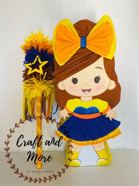 A Paper Doll With A Yellow Bow And Blue Dress Next To A Sign That Says